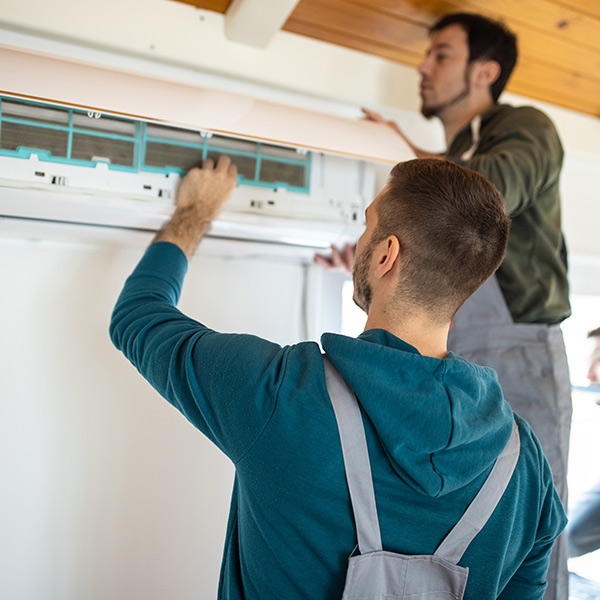 two technician fitting the air conditioner