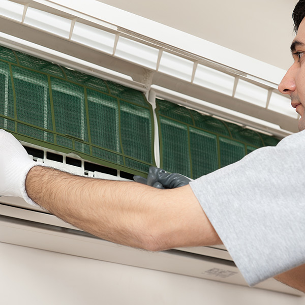 man fitting the air conditioner filter