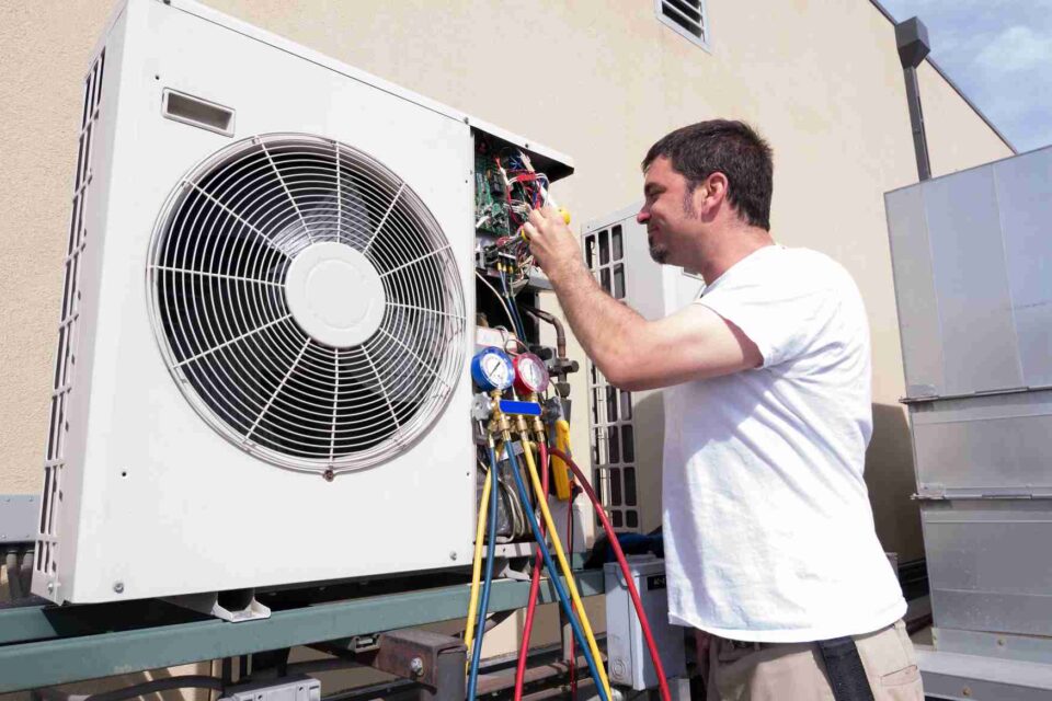 HVAC technician servicing an outdoor air conditioning condenser unit in San Joaquin County