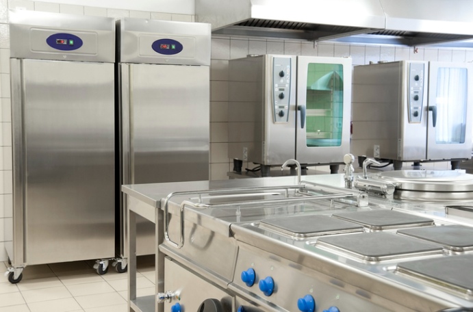 Commercial kitchen with stainless steel ovens and refrigeration units in San Joaquin County