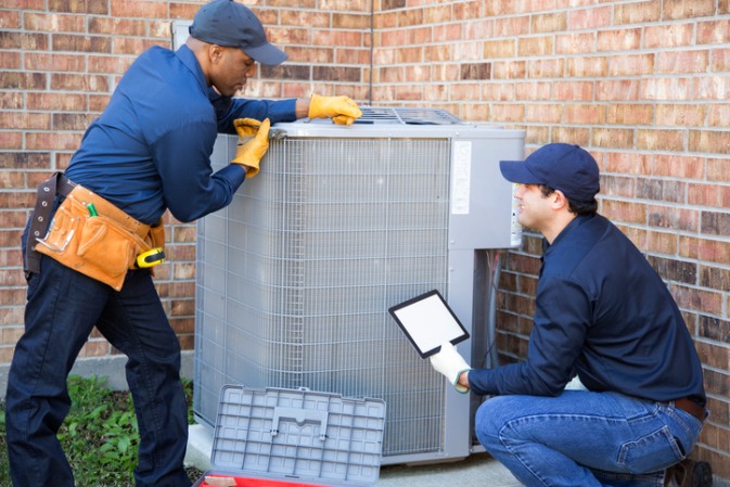 HVAC technicians inspecting a large air conditioning system in San Joaquin County