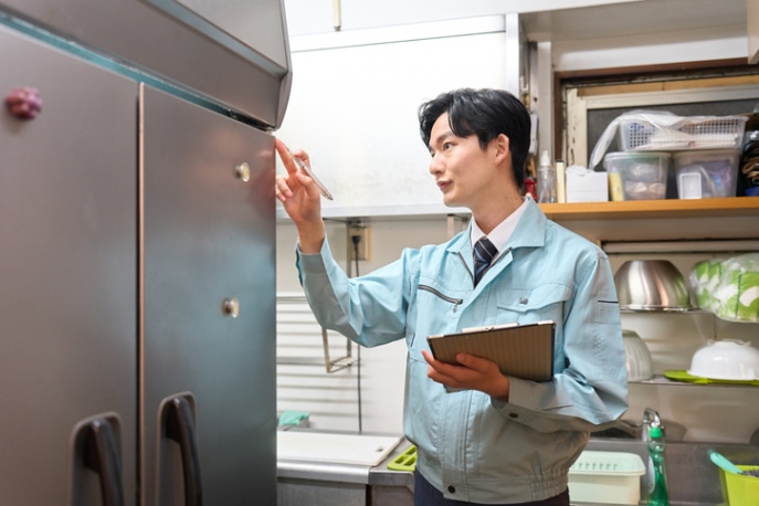 Technician inspecting commercial refrigeration unit with checklist in San Joaquin County