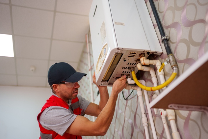 Repairing wall-mounted heating unit with pipes in San Joaquin County
